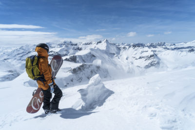 Freerider mit Snowboard im Winter auf dem Berg in Laax