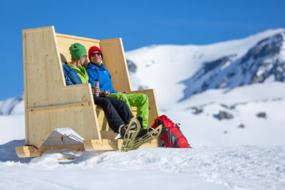 Sitting on a wooden bench in winter in the region of Flims Laax Falera