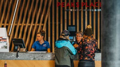 Staff and guests at the reception desk at Peaks Place Hotel Laax
