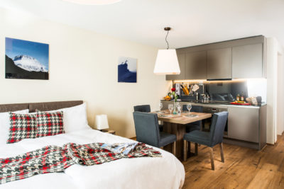 Schlafzimmer mit Esstisch in der Ferienwohnung in Laax im Aparthotel Peaks Place