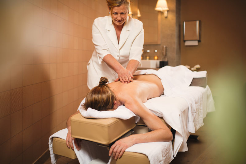 Frau massiert Frau bei Massage im Wellnessbereich La Senda im Hotel Peaks Place in Laax Flims