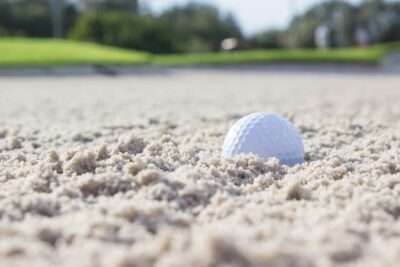 Eine Nahaufnahme eines Golfballs im Sand